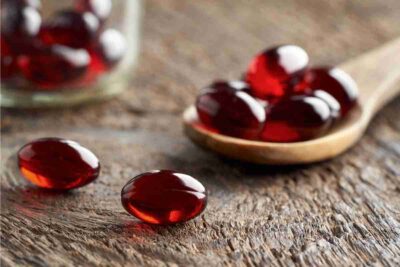 krill oil capsules on a wooden spoon