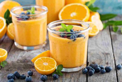 orange, banana, and grape smoothie on a table